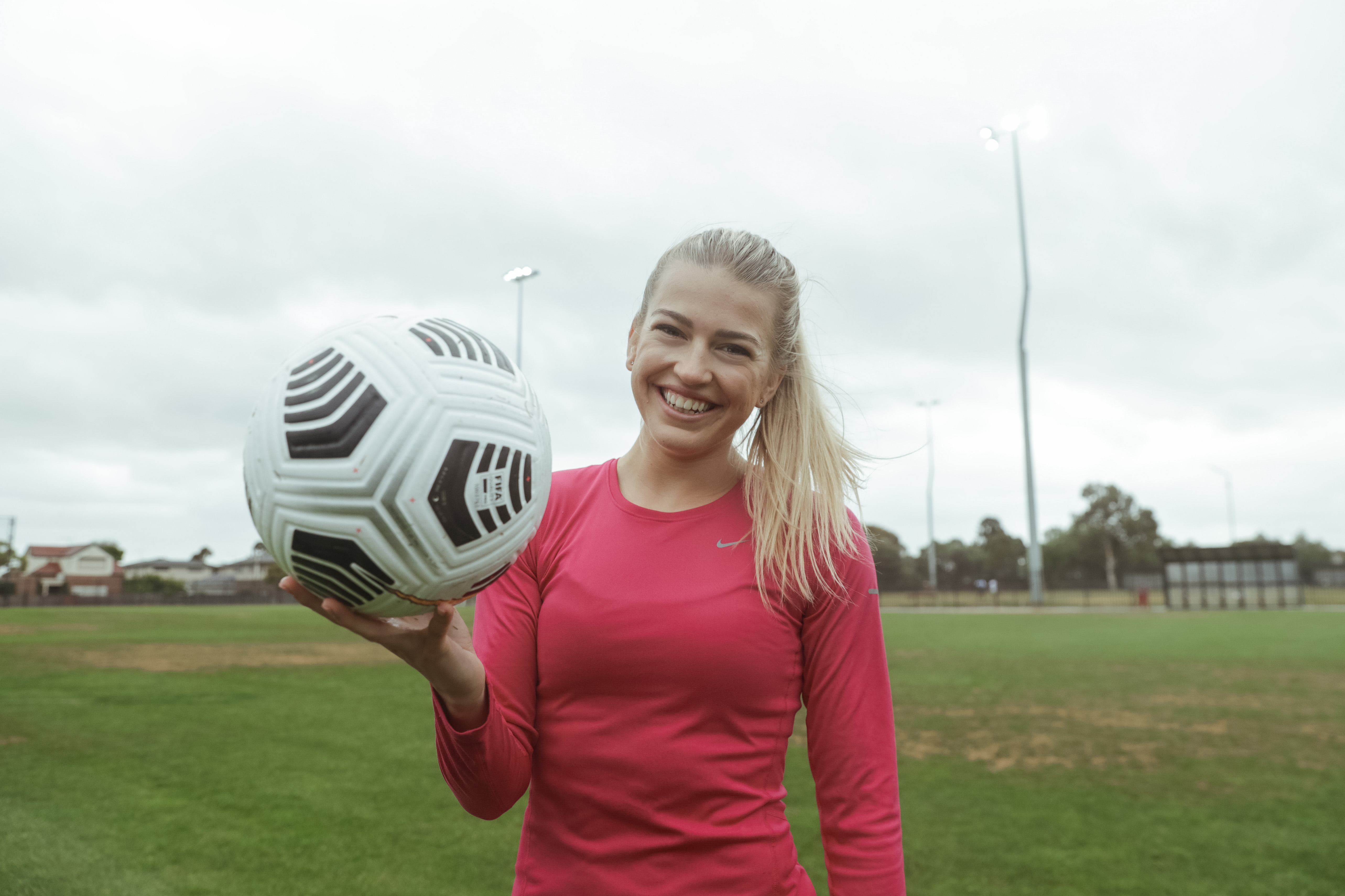 Charli Grant Charli Grant smiling at the camera whilst holding up a football