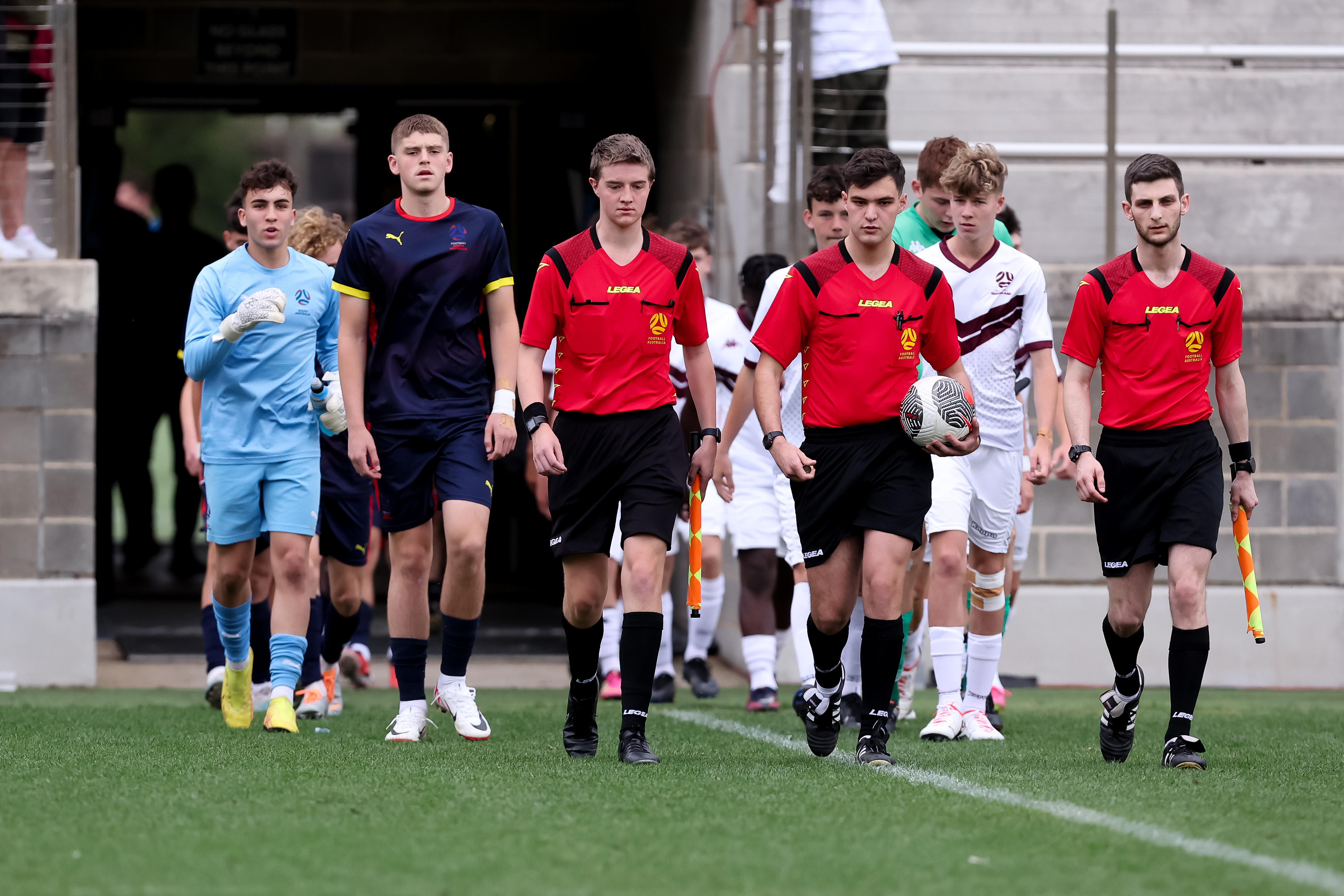 South Australia and Queensland's Under 15 Boys side walk out for their game at Valentine Sports Park.