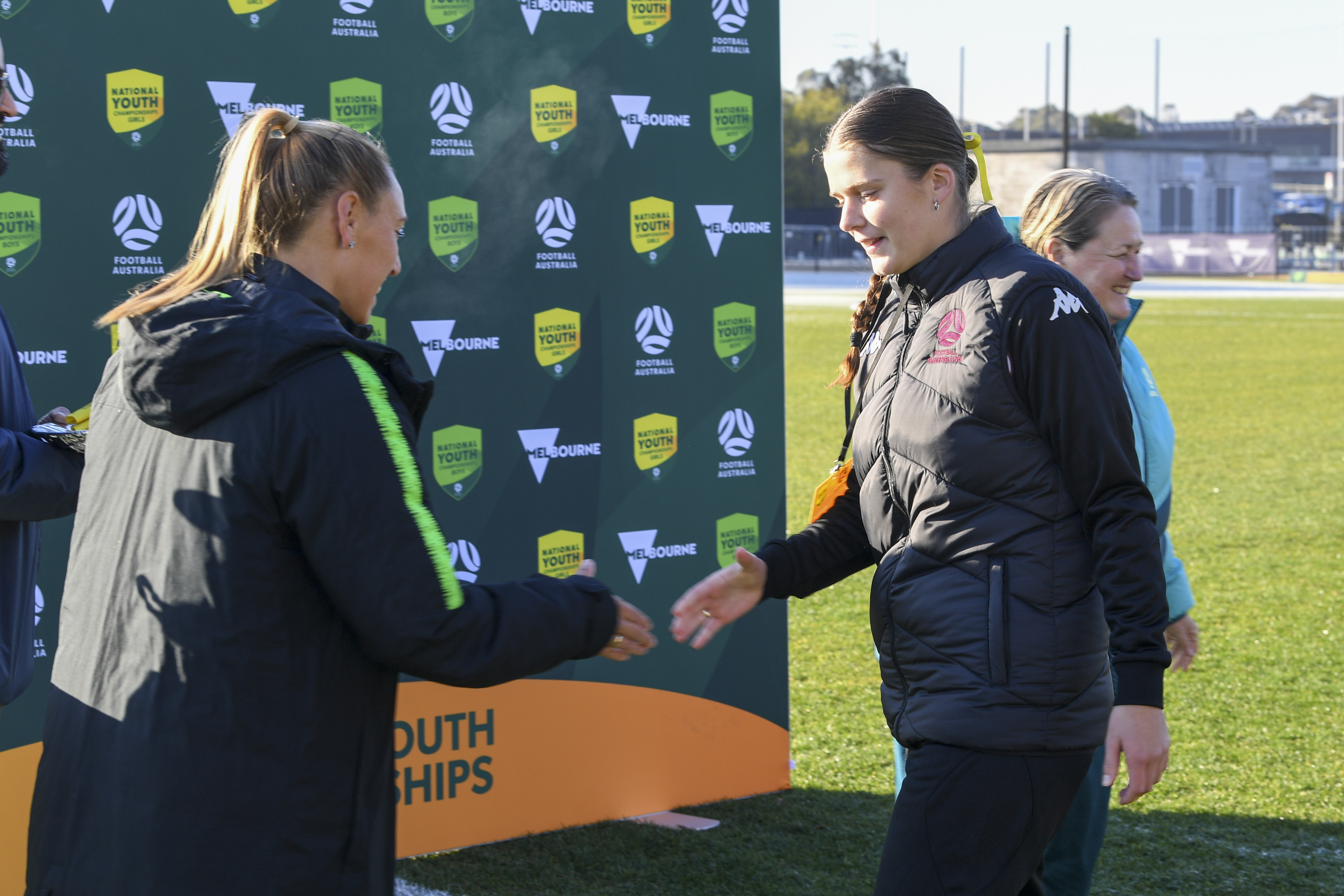 A Football Queensland player shakes hands with Gema Simon