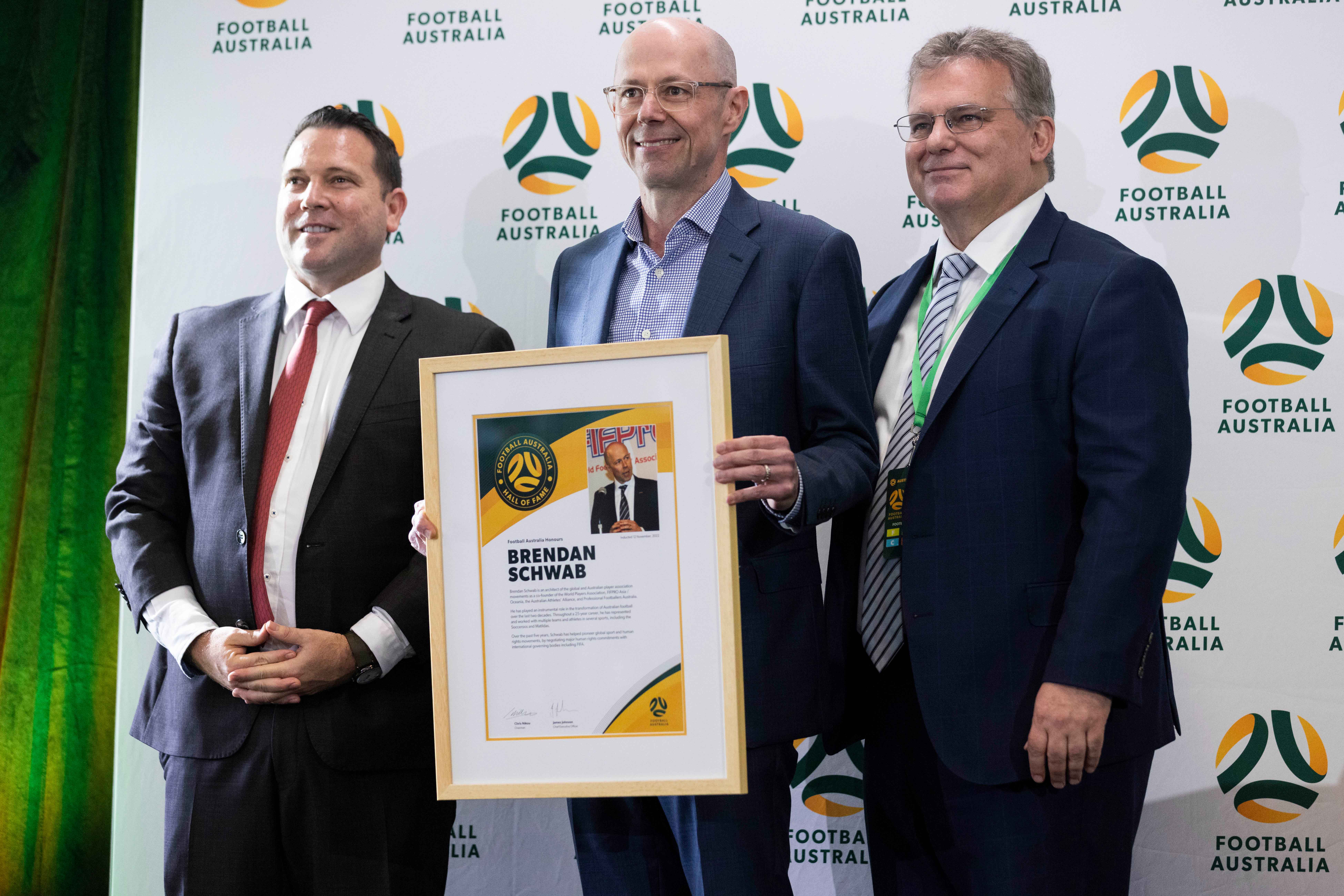 Brendan Schwab receiving his Football Australia Hall of Fame award, pictured with Football Australia CEO James Johnson and Football Australia Chair Chris Nikou. (Photo: Tiffany Williams/Football Australia)